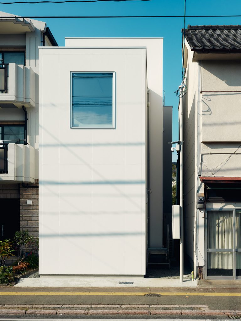 Front facade of O-Studio with three simple timber-clad volumes facing the street.
