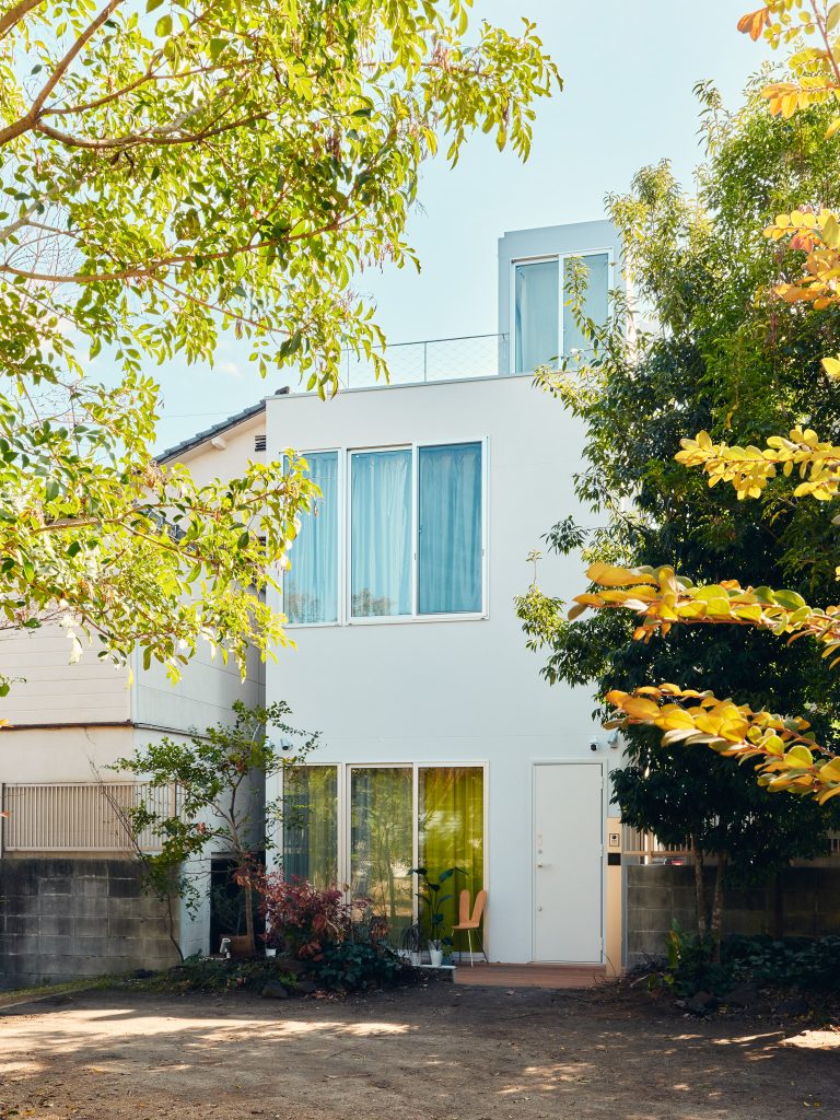 Back facade of O-Studio opening to the garden with larger windows and soft natural light.