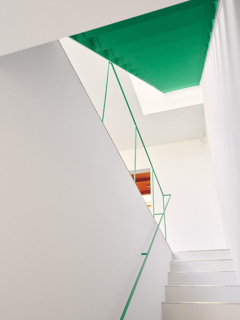 Narrow staircase inside O-Studio with muted textures and gentle daylight from above.