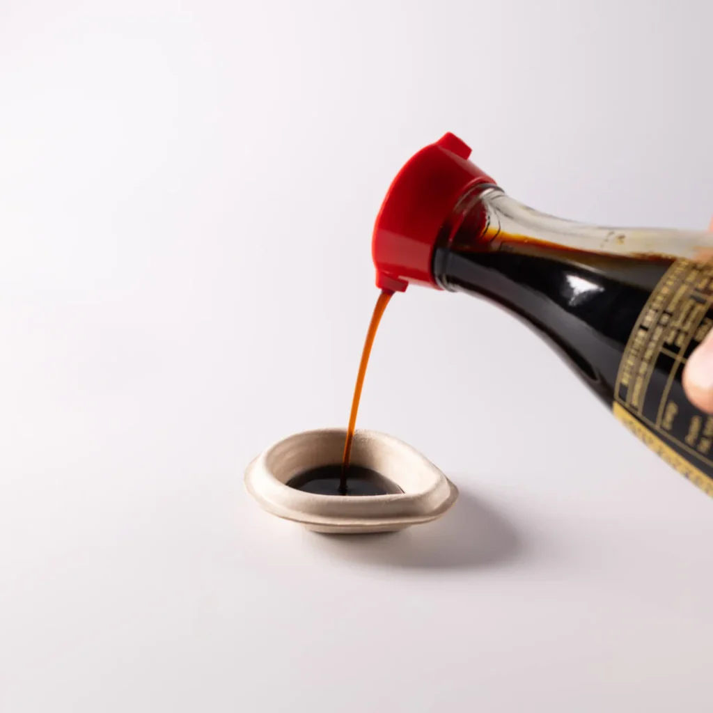 Soy sauce poured into a compostable fish-shaped dropper designed by Heliograf
