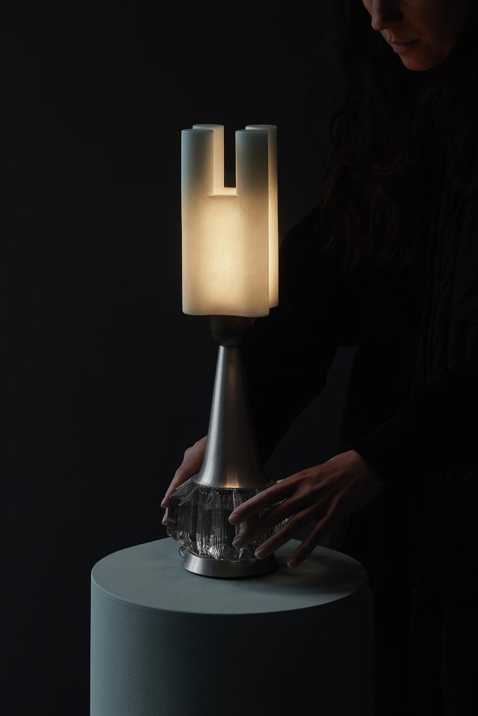 Plant-based wax modules stacked with restored vintage luminaire parts, glowing softly in a minimalist interior.